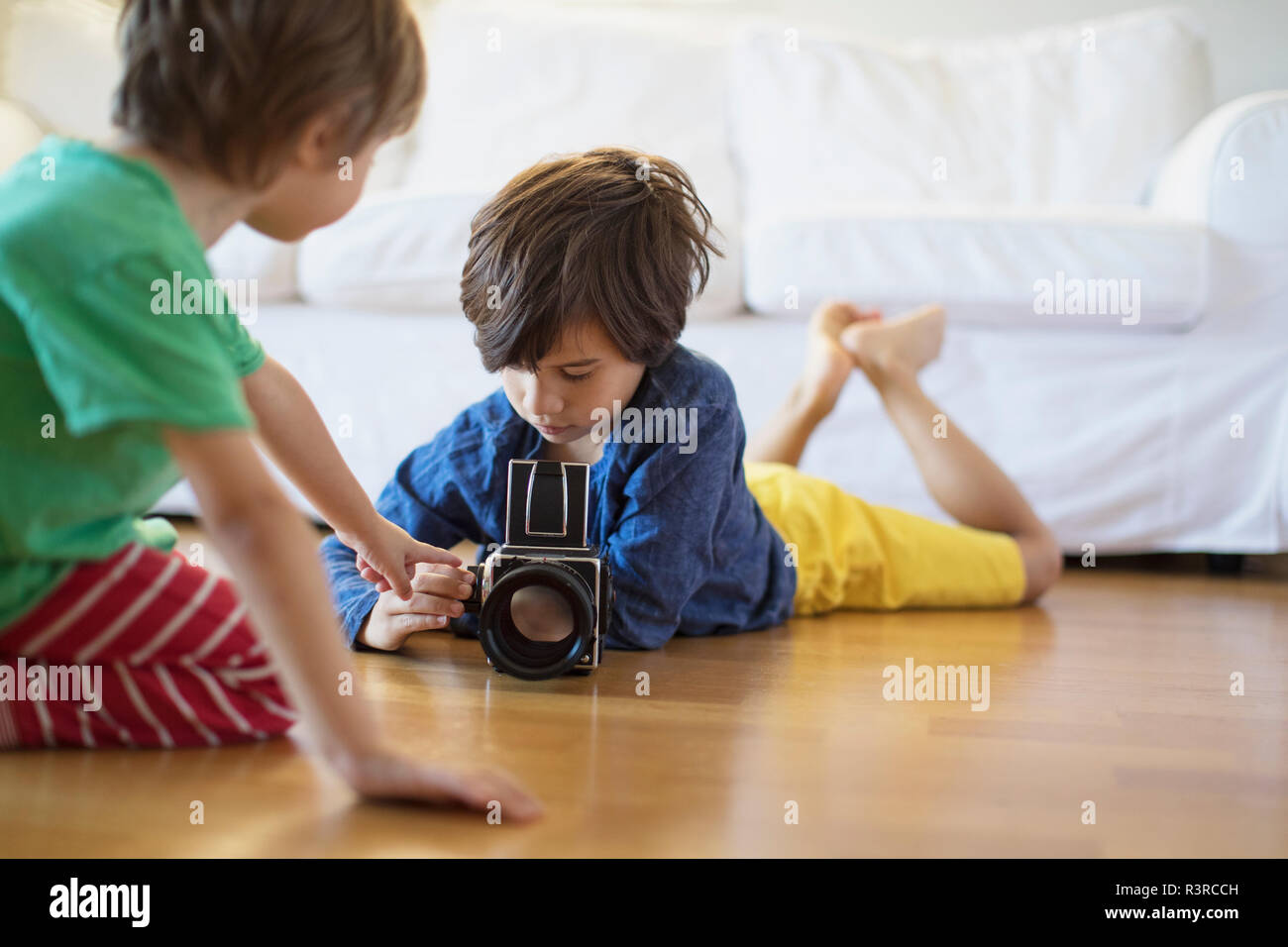 Due fratelli a casa ad esplorare una vecchia telecamera cinematografica Foto Stock