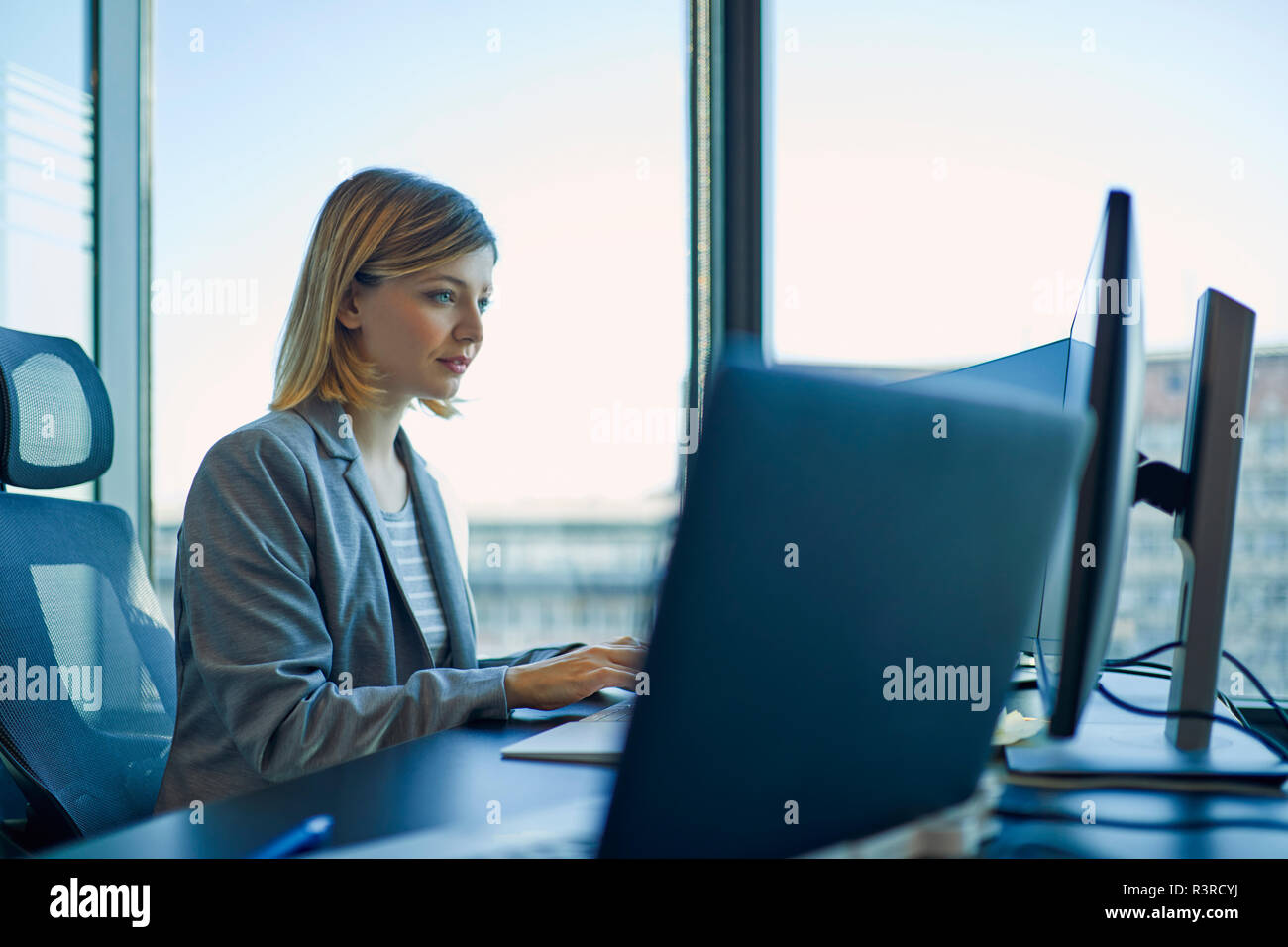 Imprenditrice utilizzando computer in ufficio Foto Stock