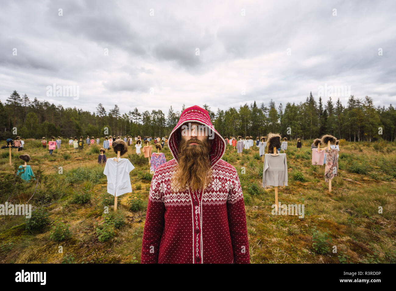 Finlandia, Suomussalmi, uomo in piedi di fronte al popolo silenzioso, arte progetto con la folla di spaventare i corvi Foto Stock
