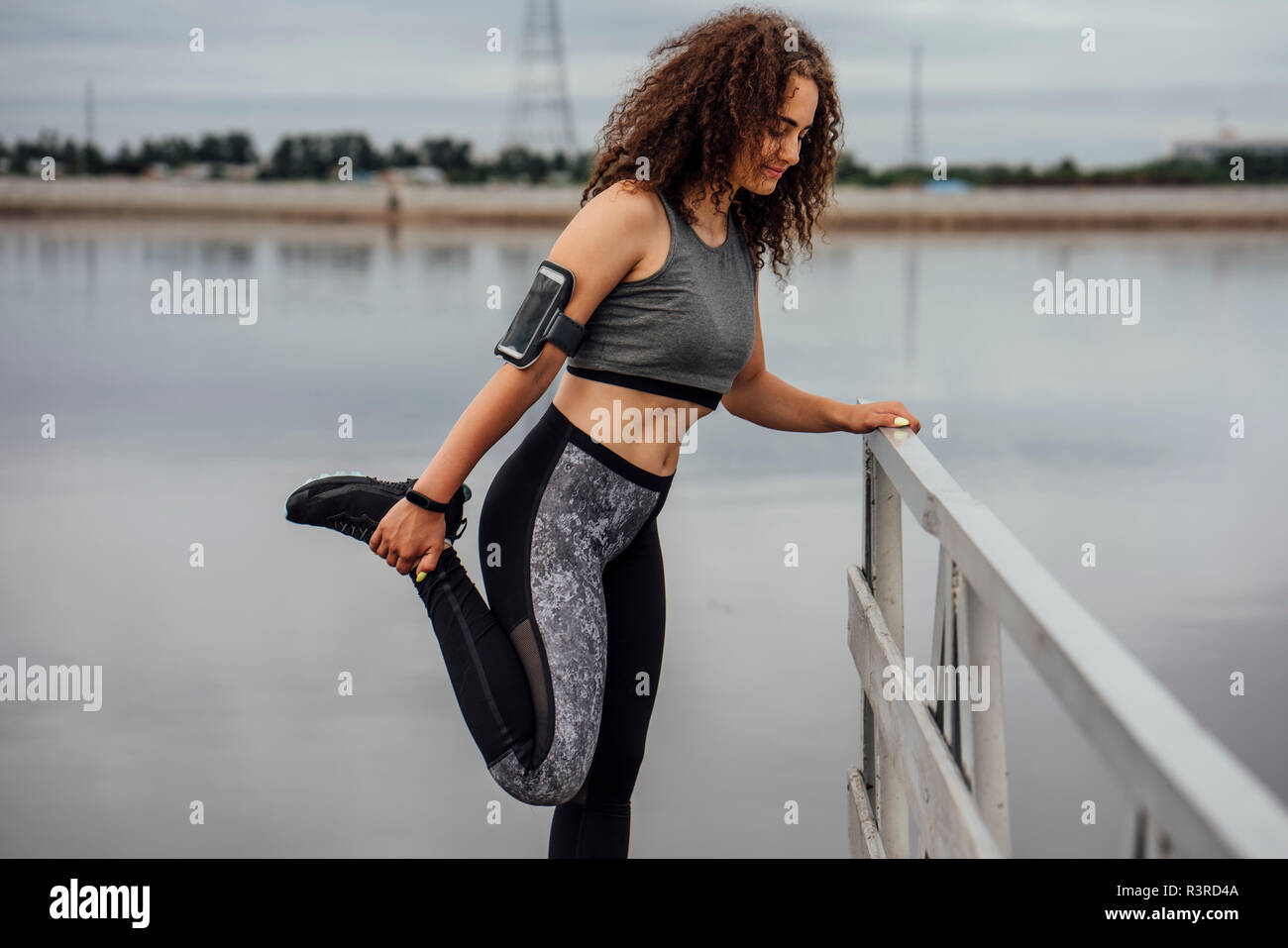 Atletica Giovane donna stretching al Riverside Foto Stock