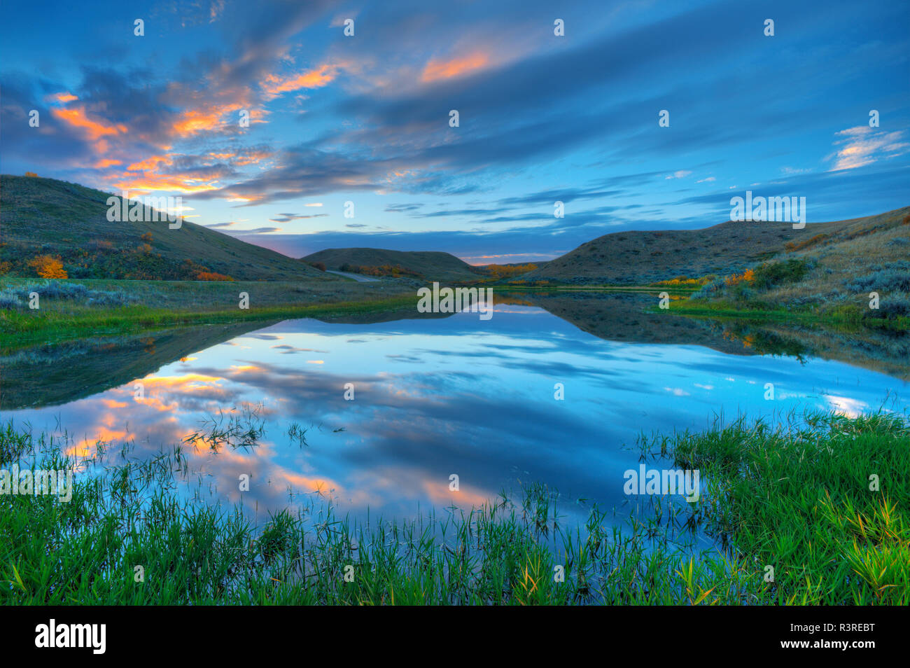 Canada, Saskatchewan, Saskatchewan Landing Parco Provinciale. Nuvole al tramonto riflesso nella zona umida. Foto Stock