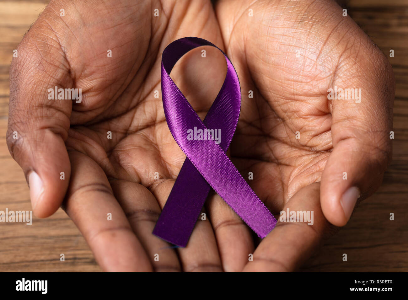 Close-up di una persona della mano che tiene il nastro per supportare il morbo di Alzheimer consapevolezza Foto Stock