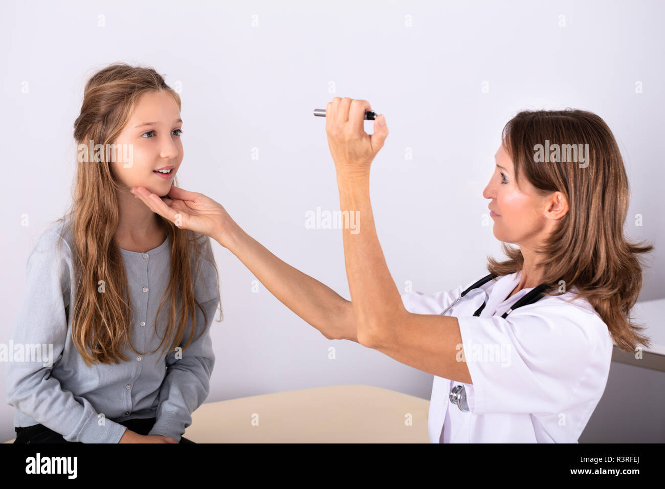 Femmina matura medico esaminando ragazza occhio del paziente in Clinica Foto Stock