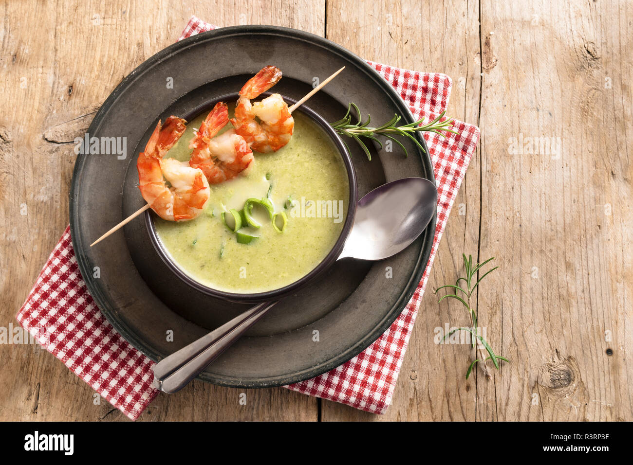 Gli spiedini di gamberi e porri minestra di crema su una tavola in legno rustico, vista in pianta da sopra con lo spazio di copia Foto Stock Gli spiedini di gamberi e porri minestra di crema su una tavola in legno rustico, vista in pianta da sopra con lo spazio di copia Foto Stock