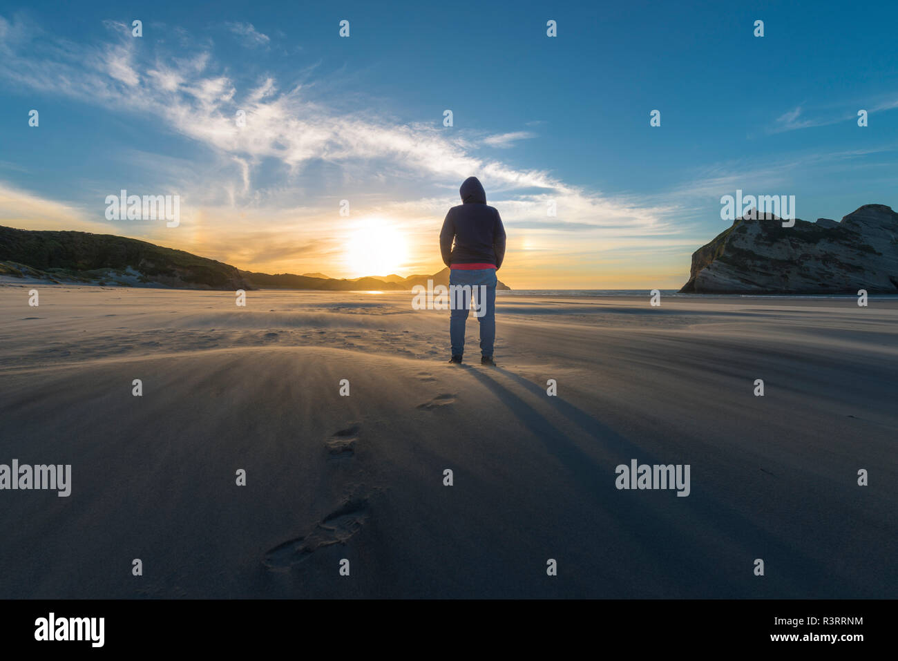 Nuova Zelanda, Isola del Sud, Puponga, Wharariki Beach, donna sulla spiaggia al tramonto Foto Stock