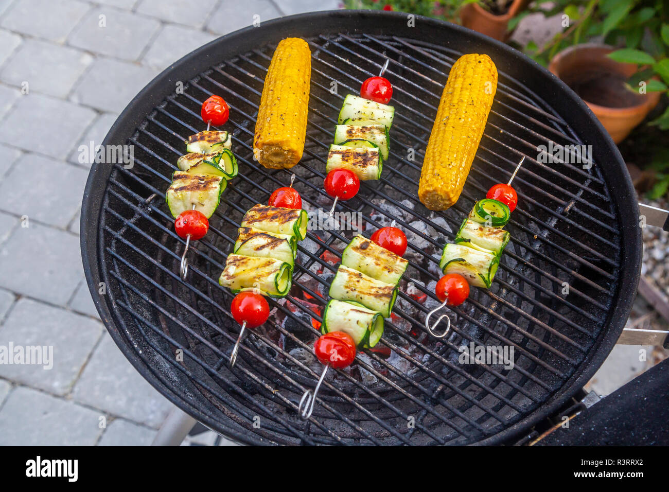 Grigliata grill vegetariano spiedini, pomodoro, formaggio di pecora e fette di zucchine, pannocchie di granoturco sulla griglia Foto Stock