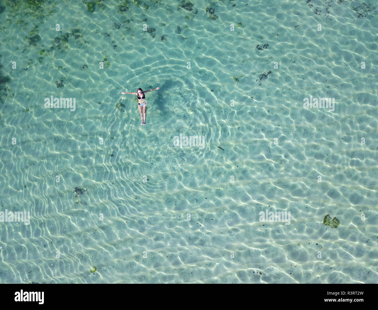 Indonesia, Bali, Melasti, vista aerea del Karma Kandara beach, donna galleggiante sull'acqua Foto Stock