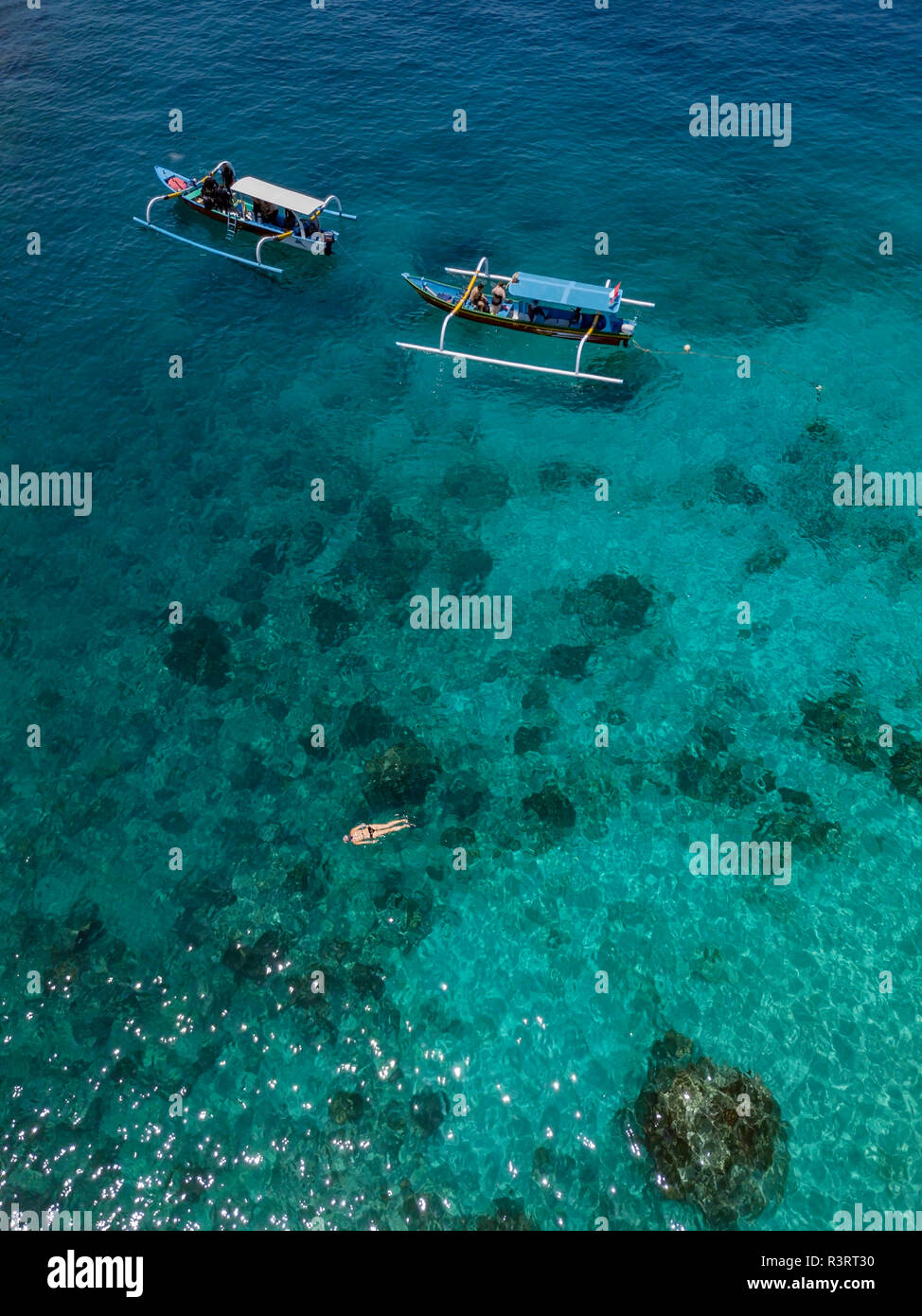 Indonesia, Bali, veduta aerea della laguna blu, snorkeler e banca barche Foto Stock