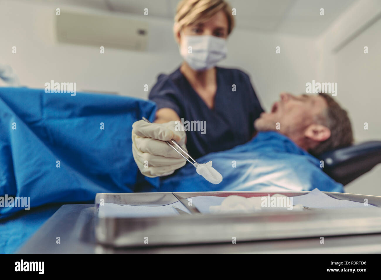 Chirurgo dentista durante intervento chirurgico su un paziente Foto Stock