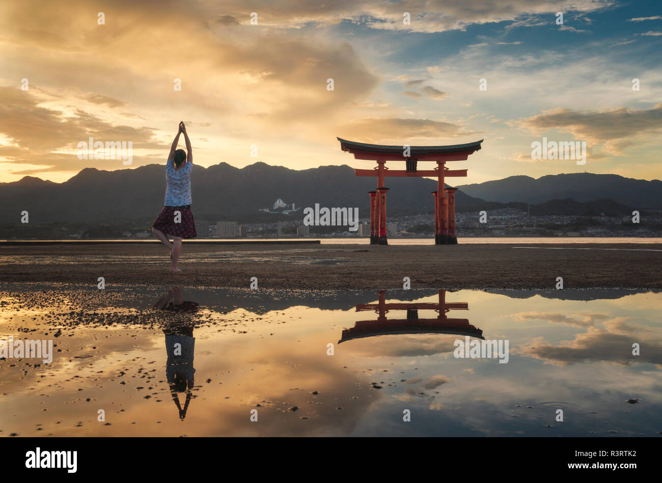 Donna godendo il tramonto sull'isola di Itsukushima o Miyajima, Hiroshima, Giappone Foto Stock