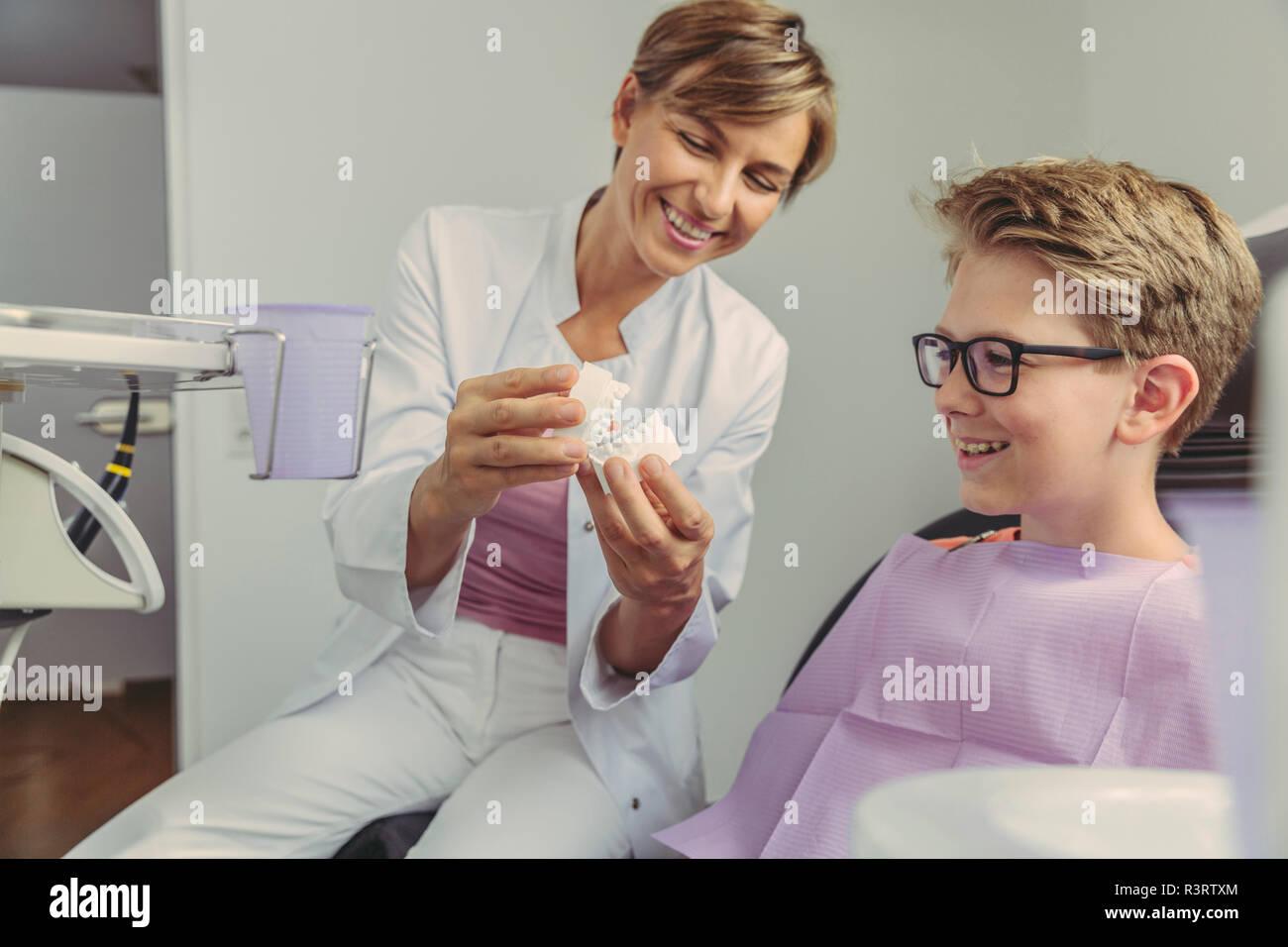 Dentista femmina spiegando ragazzo un modello di denti Foto Stock