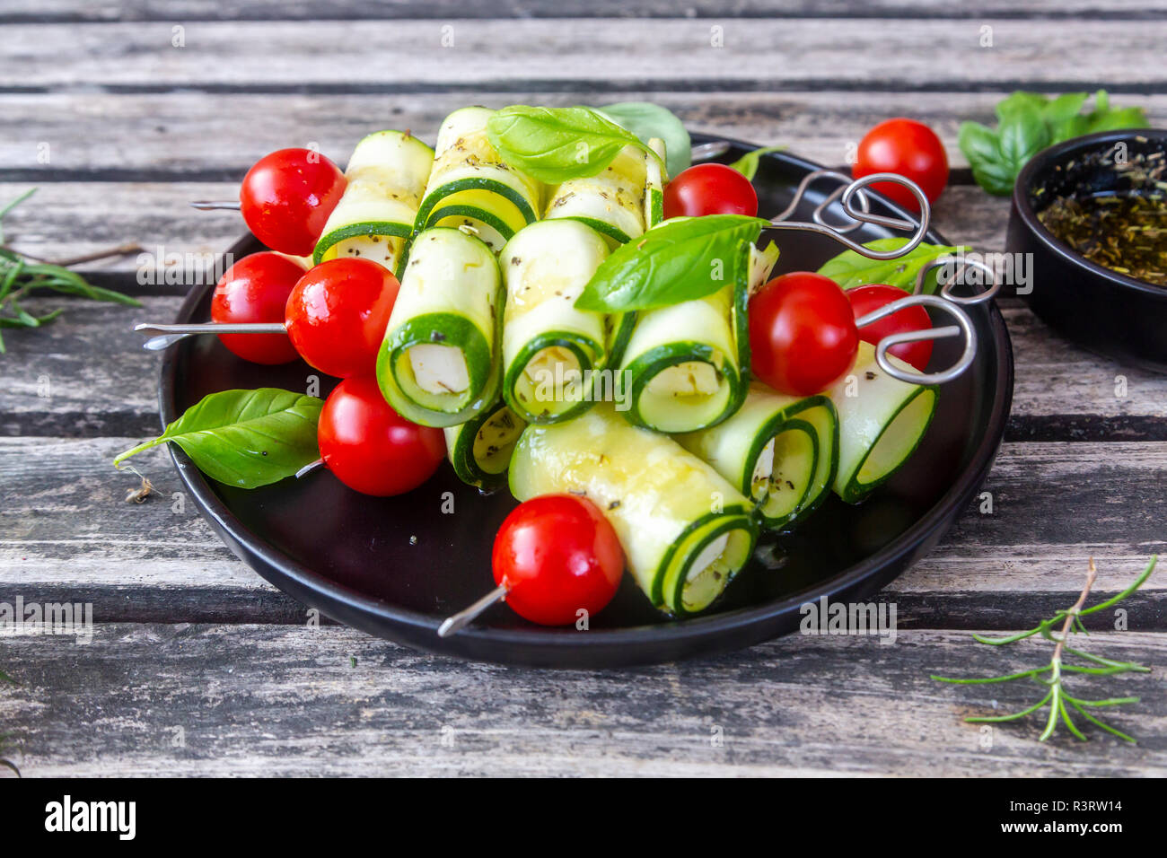Grill vegetariano spiedini, pomodori e zucchine a fette, rosmarino Olio di aglio Foto Stock