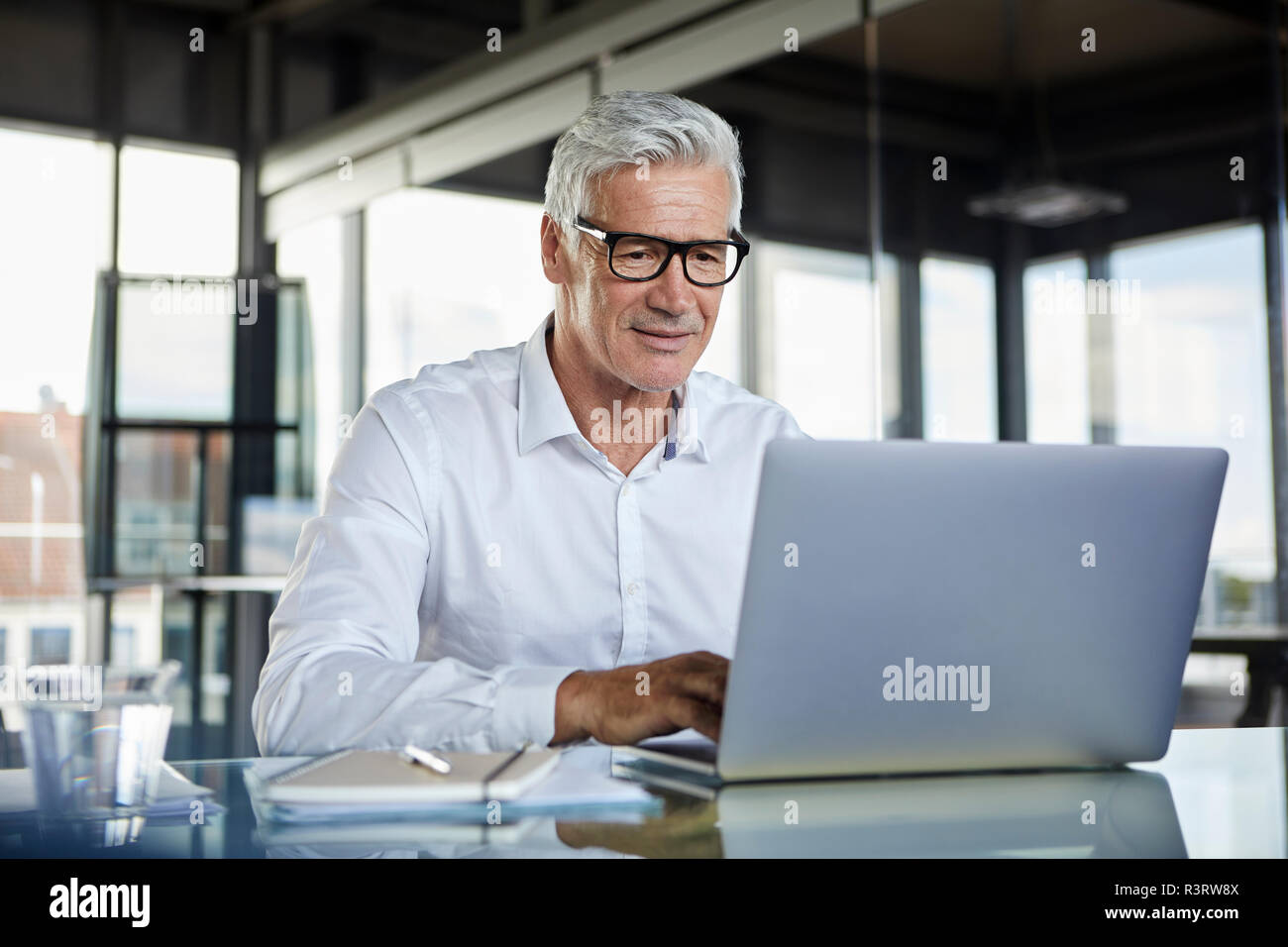 Imprenditore lavora in ufficio, con il computer portatile Foto Stock