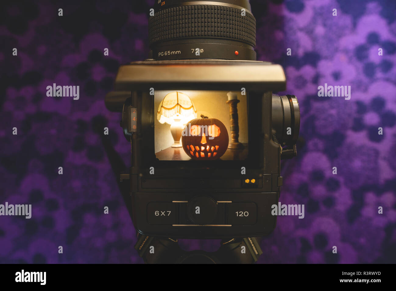 Un scolpito zucca di Halloween visto attraverso un mirino sullo schermo di un computer vintage fotocamera medio formato - astratto concetto di Halloween Foto Stock