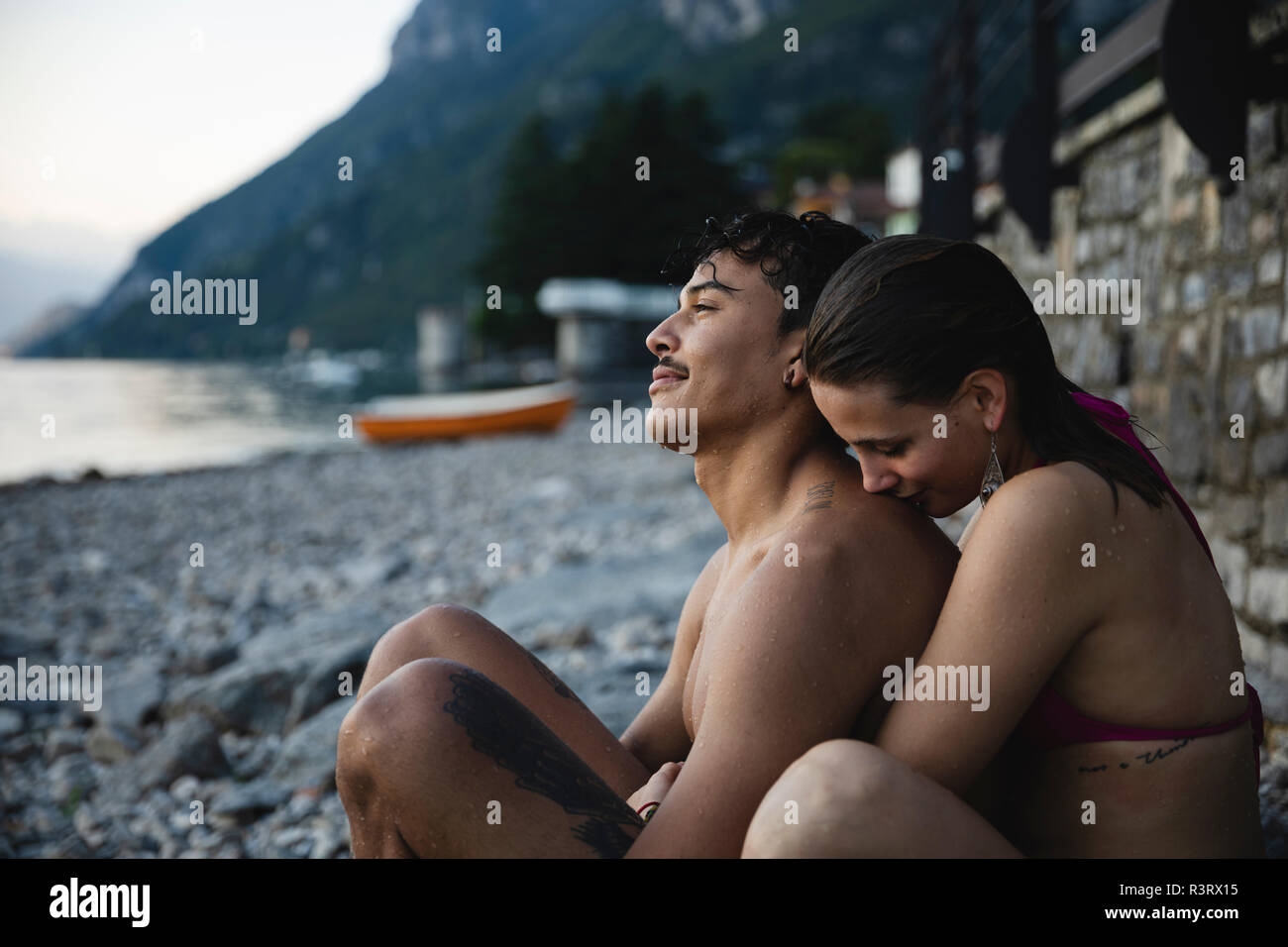 Affettuosa coppia giovane rilassante dopo assunzione di un bagno in un lago Foto Stock