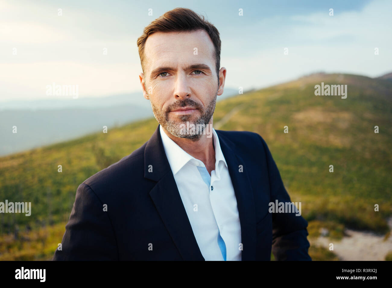 Ritratto di auto-imprenditore fiducioso sulla cima di una montagna Foto Stock