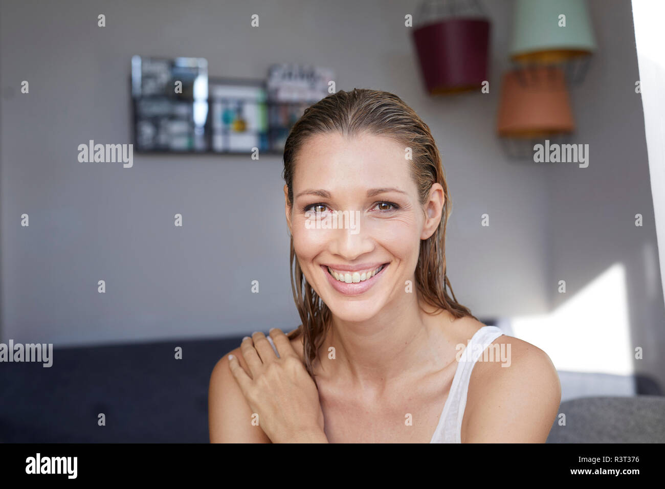 Ritratto di ridere donna bionda con capelli bagnati a casa Foto Stock