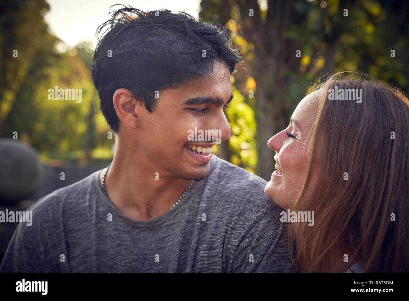 Felice coppia giovane flirtare in un parco in estate Foto Stock