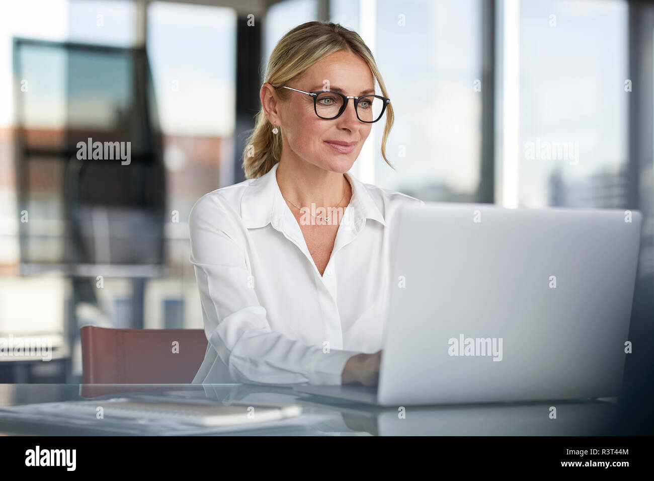 Imprenditrice che lavorano in ufficio, con il computer portatile Foto Stock