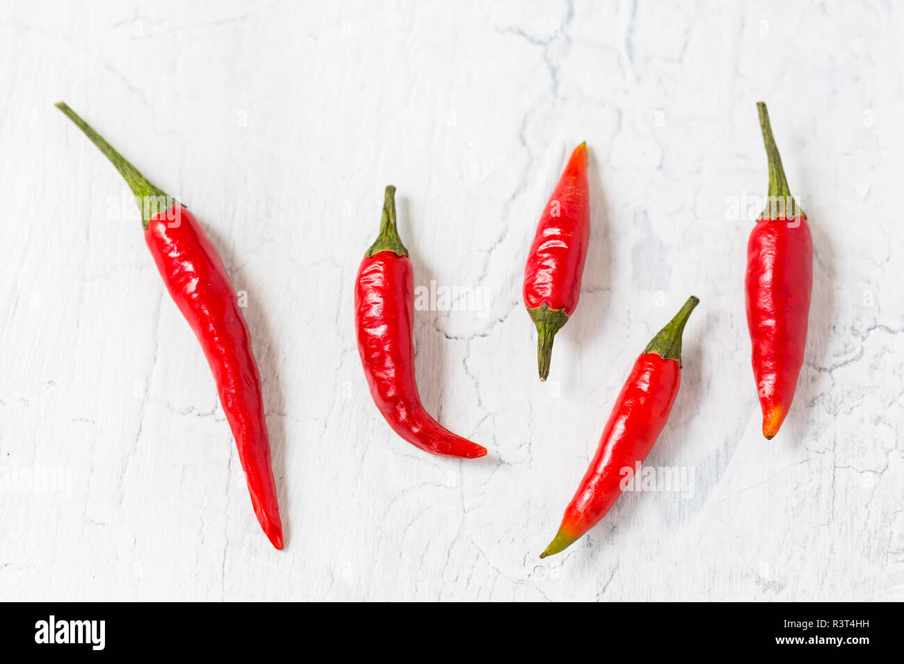5 peperoncino rosso baccelli sulla massa di luce Foto Stock