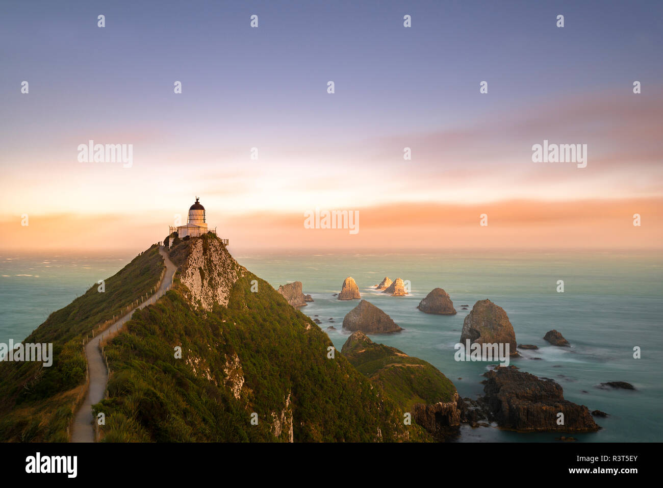 Nuova Zelanda, Isola del Sud, Otago, Nugget Point Lighthouse al tramonto Foto Stock