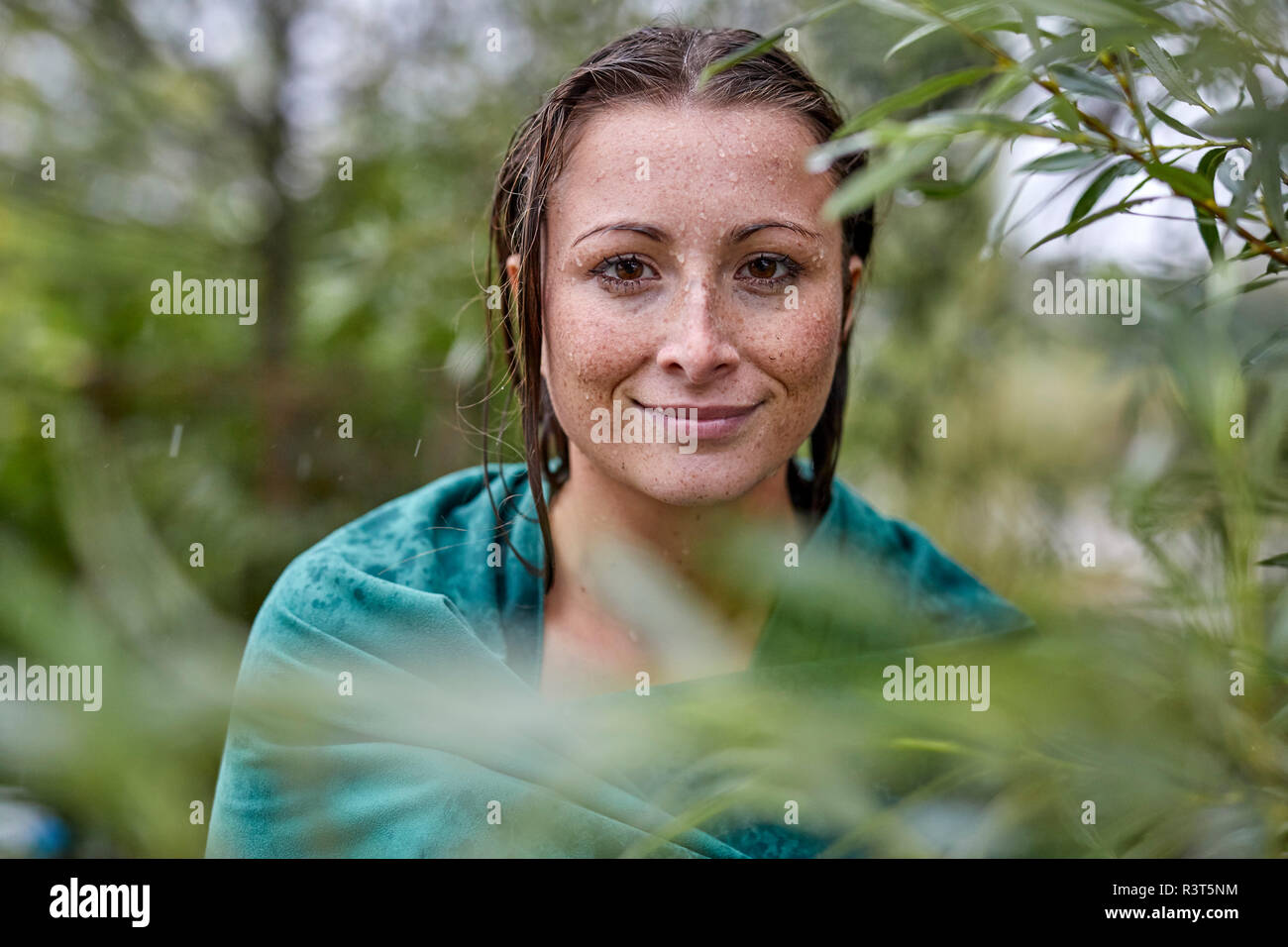 Ritratto di freckled giovane donna con wet viso e capelli avvolti in asciugamano Foto Stock