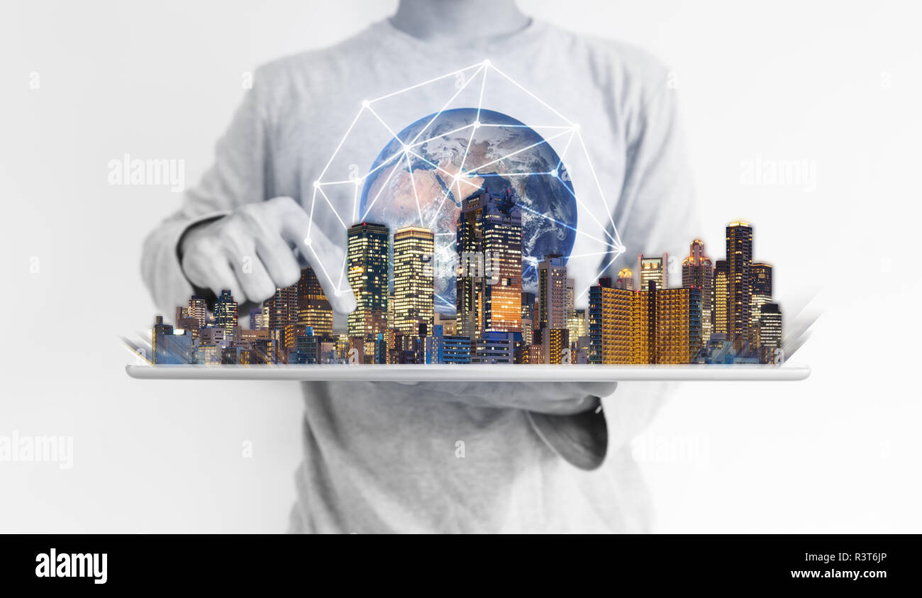 Un uomo con tavoletta digitale con un edificio moderno e una rete globale di tecnologia di connessione ologramma. Elemento di questa immagine sono arredate dalla NASA Foto Stock