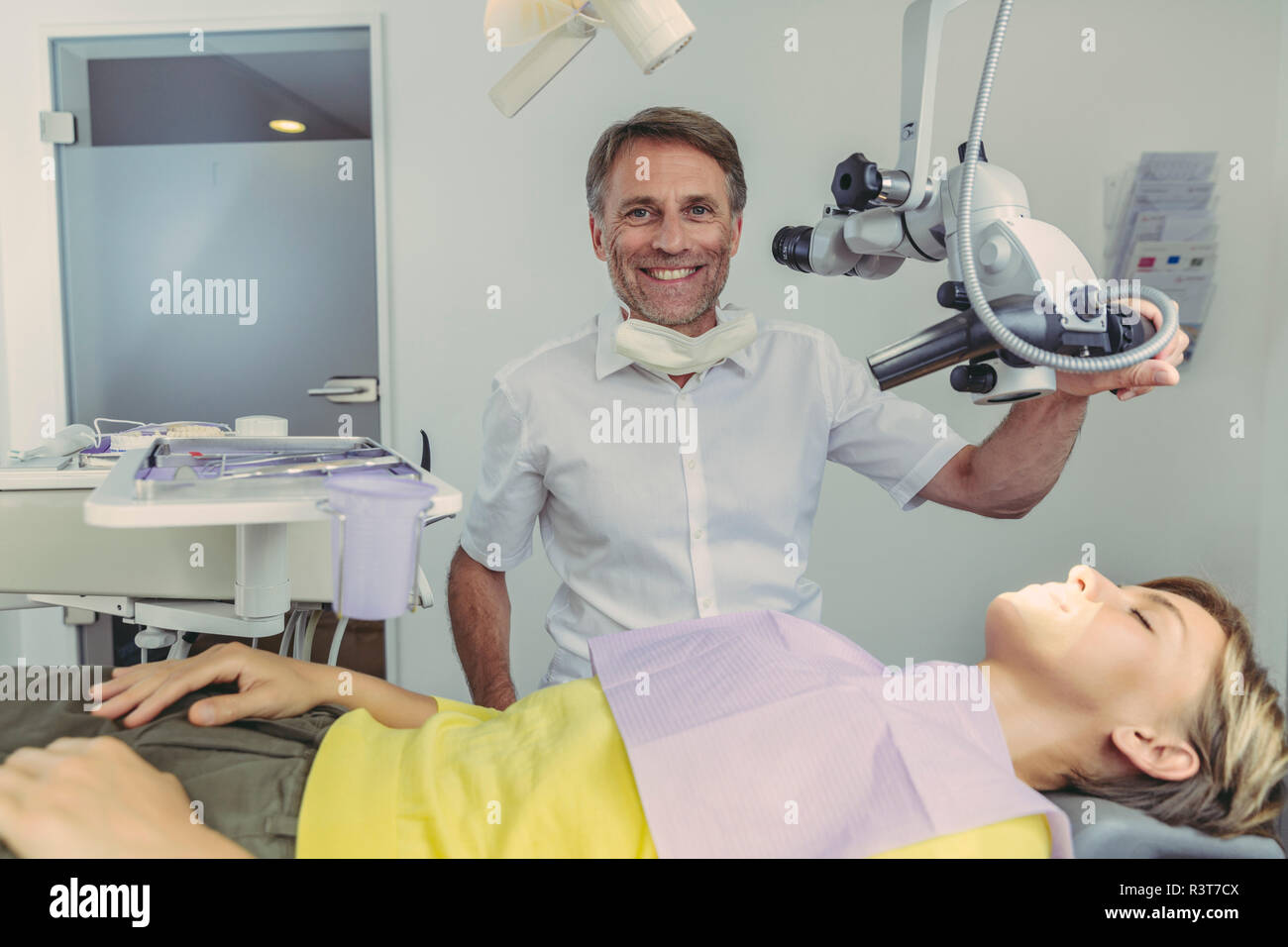 Dentista esaminando il suo paziente, mediante microscopio dentale Foto Stock