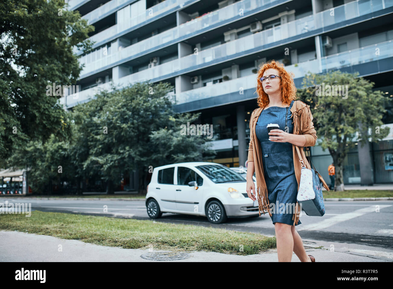 Donna di andare a lavorare con un prendere il caffè Foto Stock