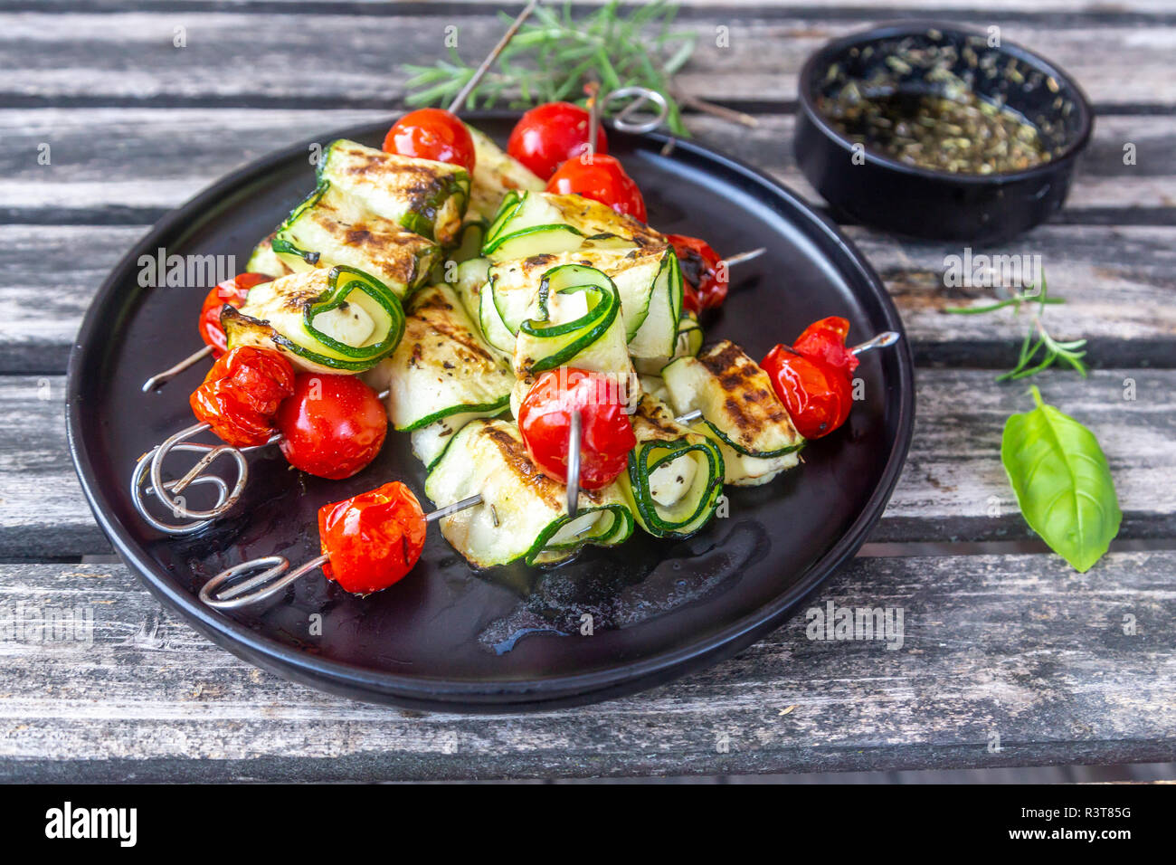 Grigliata grill vegetariano spiedini, pomodoro, formaggio di pecora e fette di zucchine, rosmarino Olio di aglio Foto Stock
