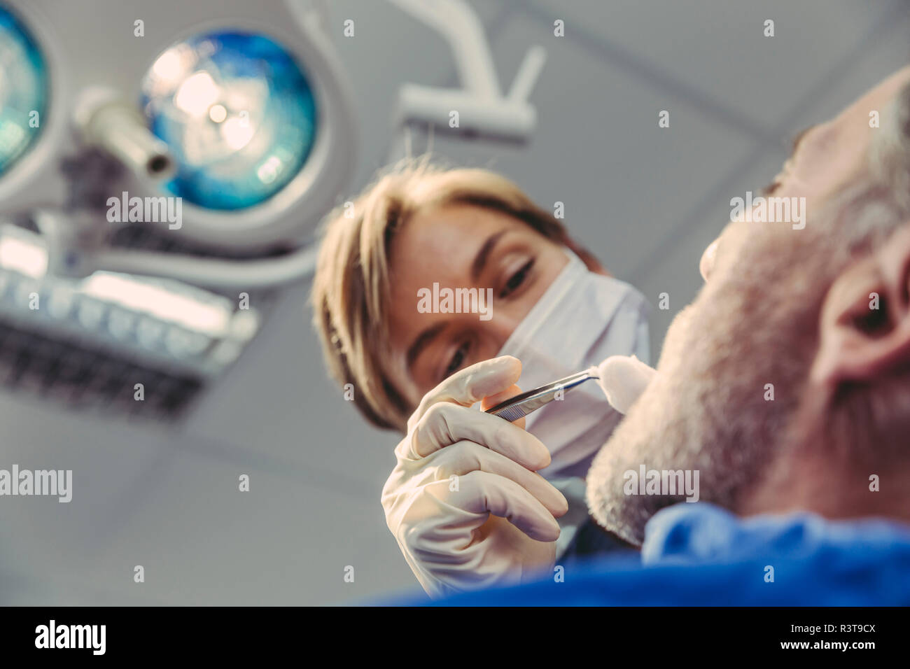 Chirurgo dentista durante intervento chirurgico su un paziente Foto Stock