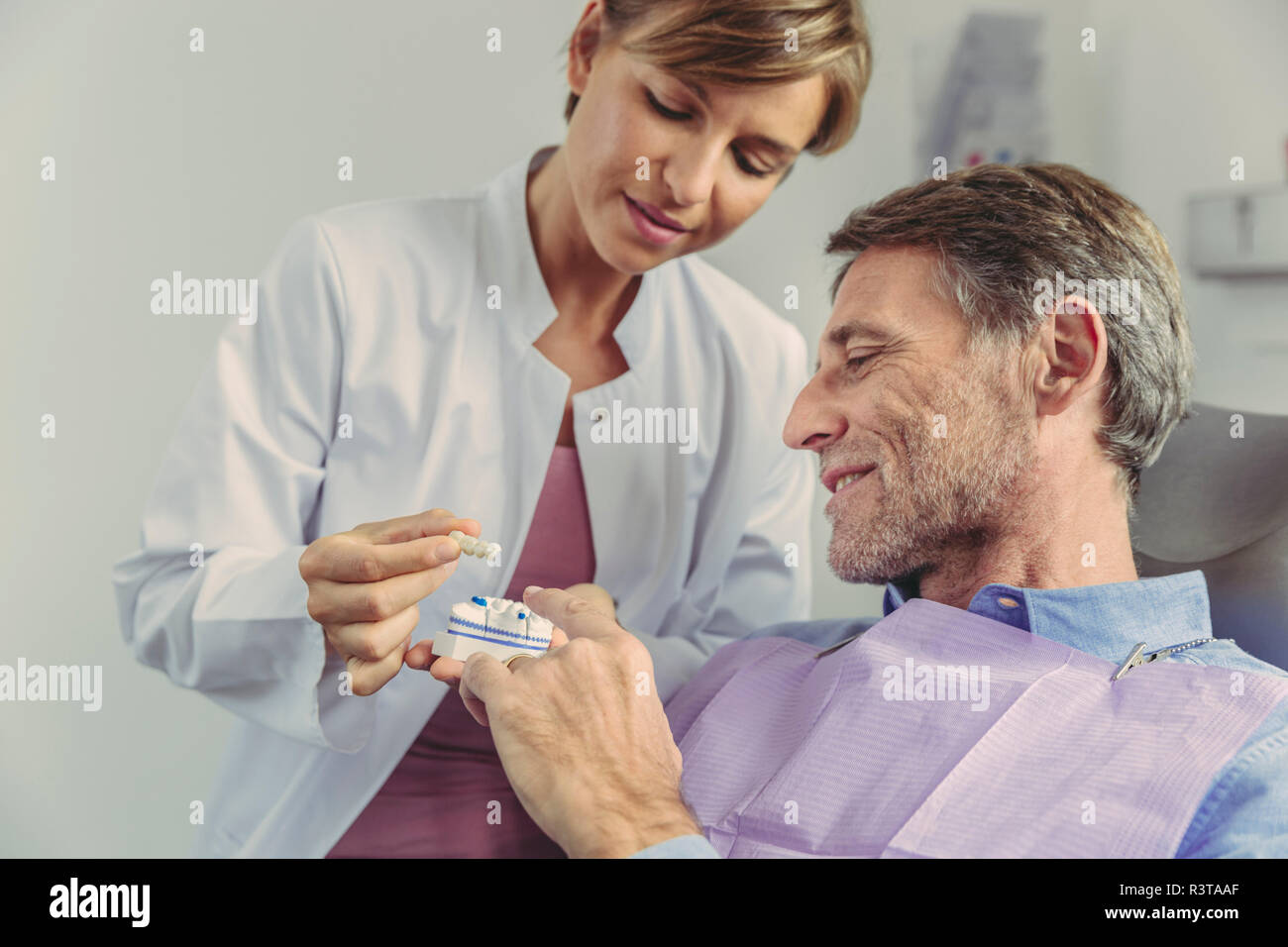 Dentista spiegando ponte dentale su un modello di denti per il paziente Foto Stock