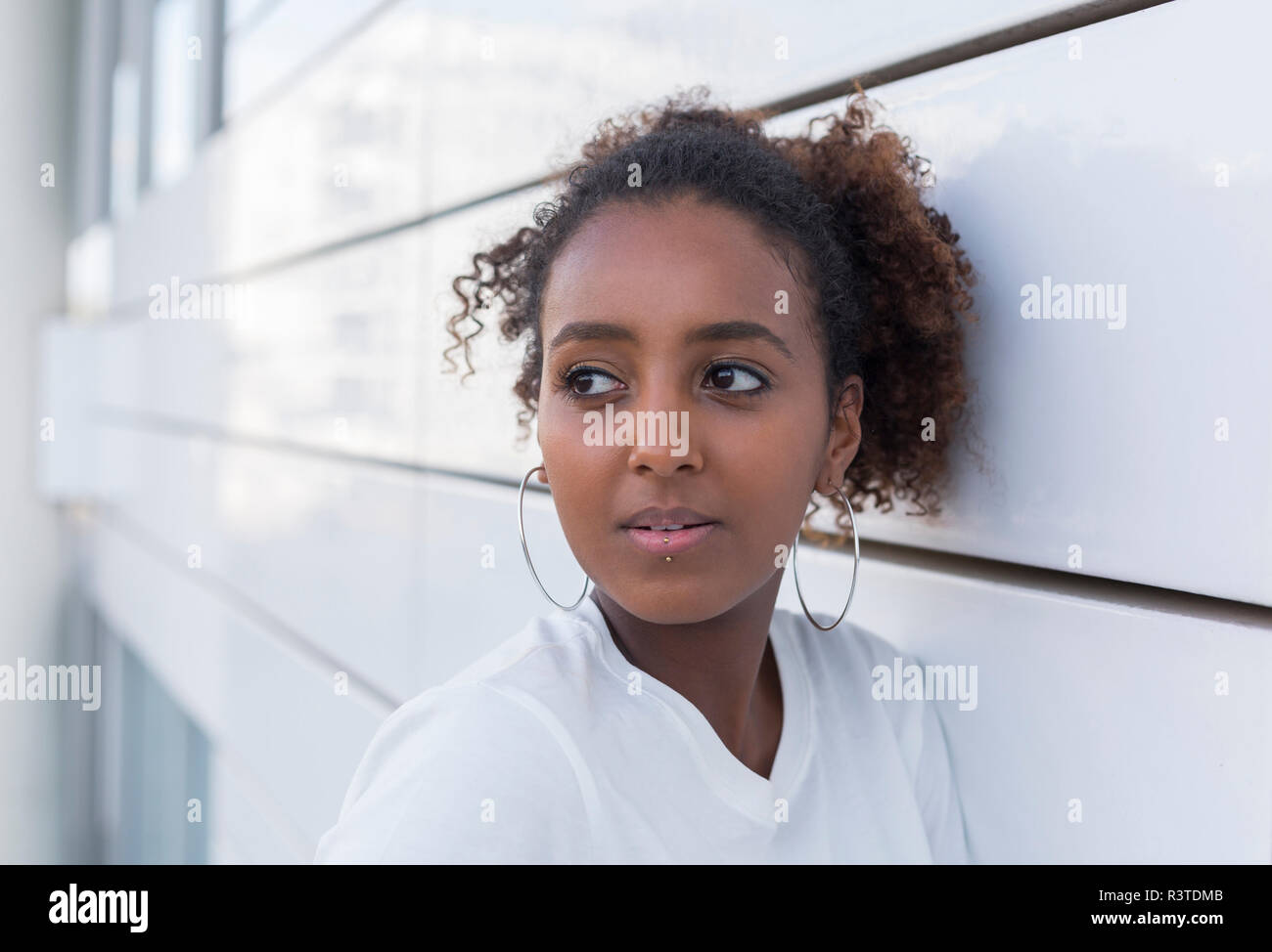 Ritratto di giovane donna con labbro piercing e grandi orecchini Foto Stock