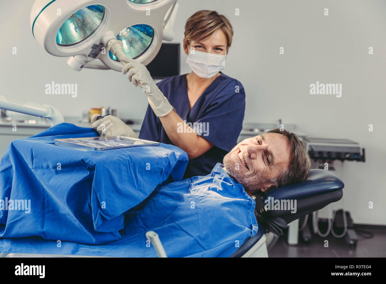 Paziente sorridente al chirurgo dentista dopo un trattamento di successo Foto Stock
