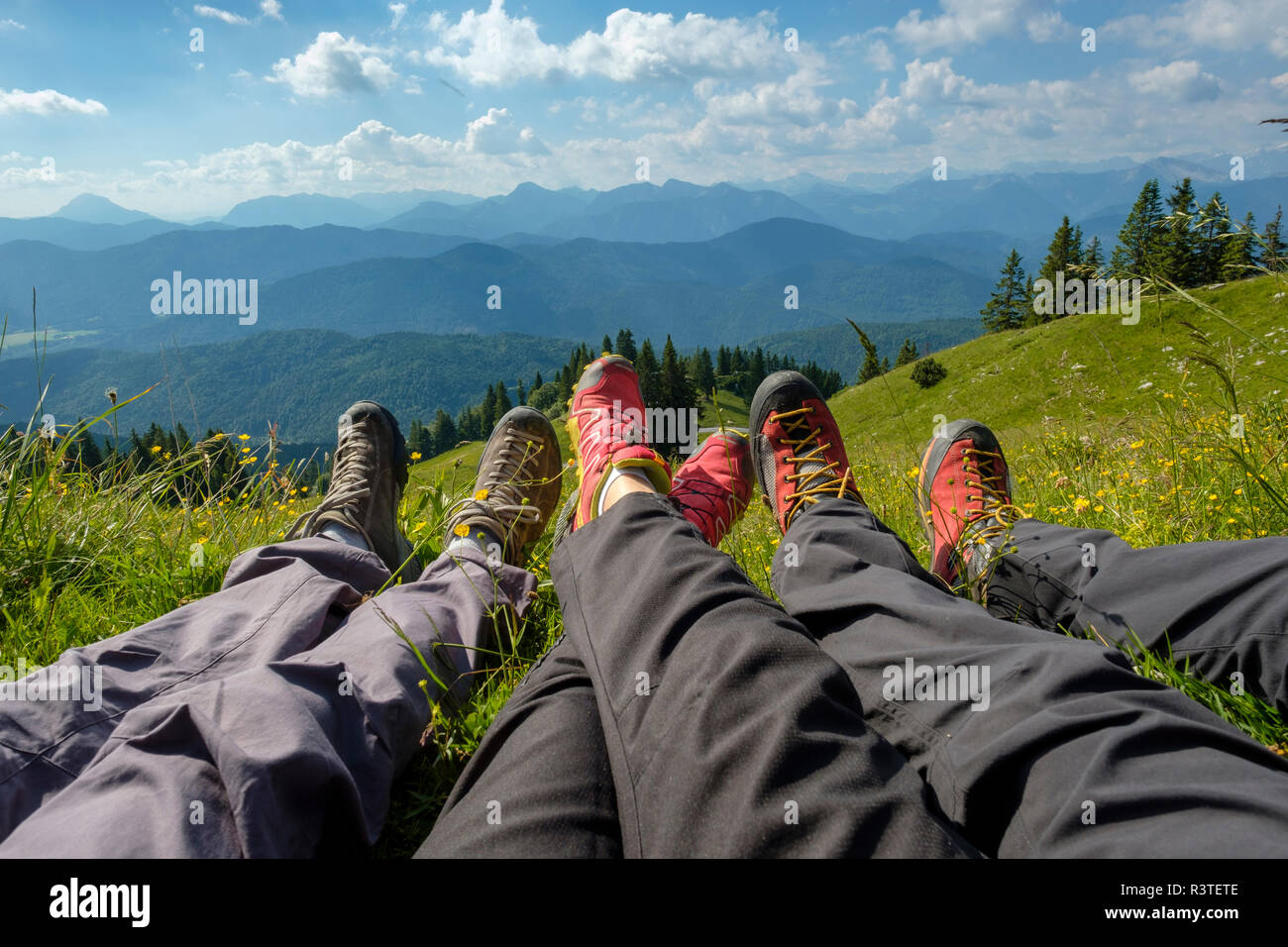 In Germania, in Baviera, vicino Brauneck Lenggries, gambe di escursionisti in prato nel paesaggio alpino Foto Stock