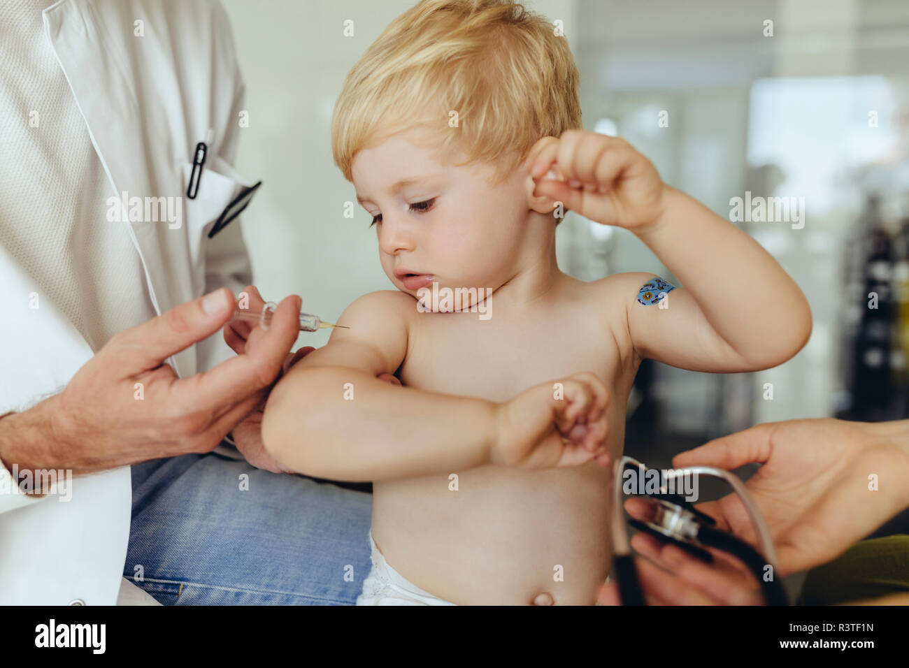 Pediatra vaccinare toddler, iniettando il neonato del braccio Foto Stock
