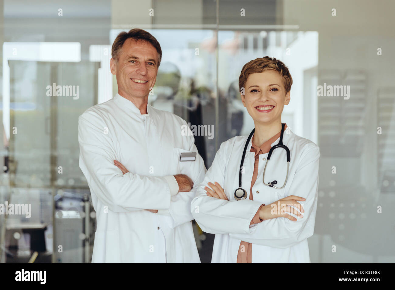 Due medici di fiducia in piedi in pratica con le braccia incrociate Foto Stock