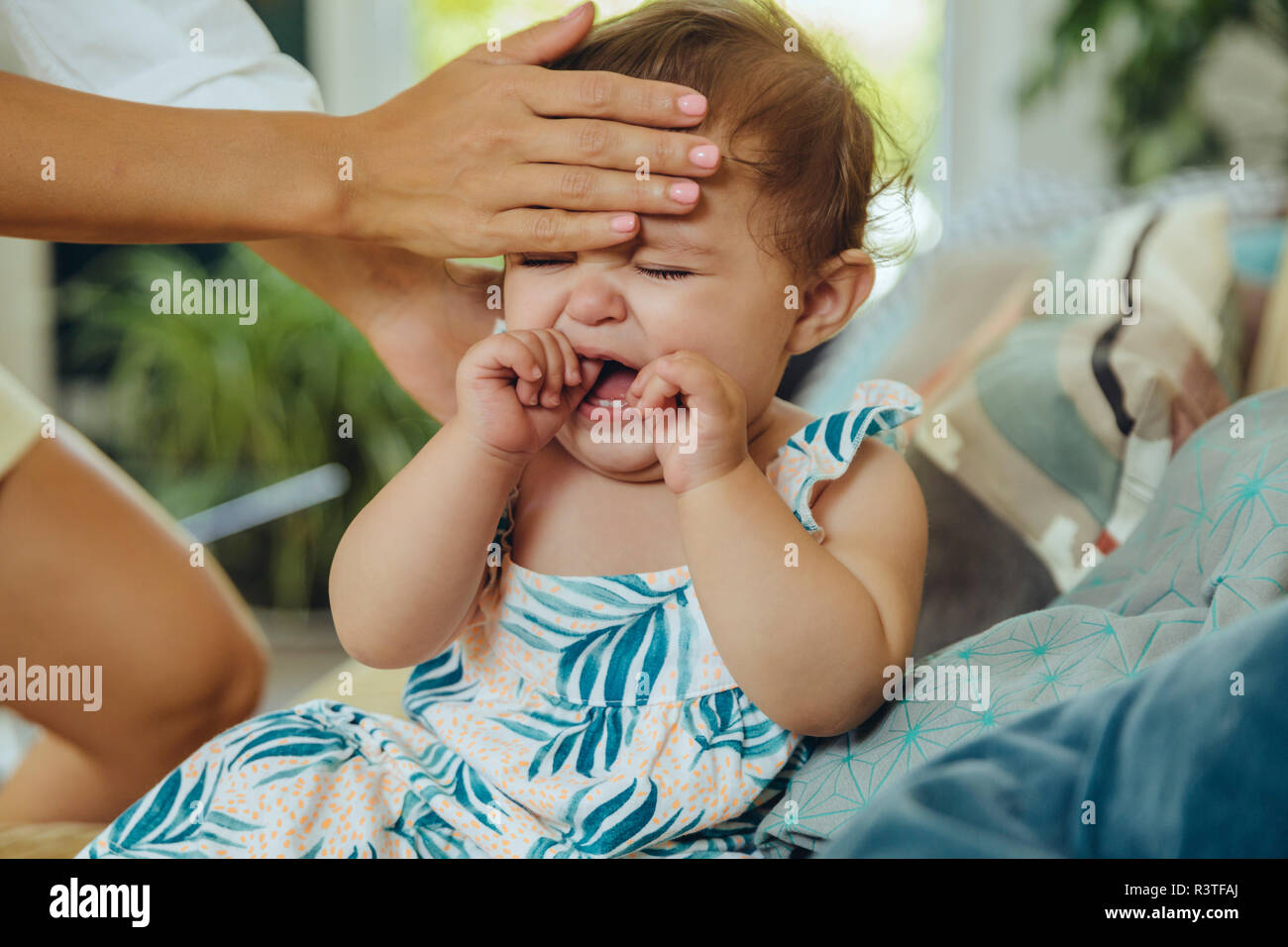 Madre tenendo la temperatura del suo pianto Baby girl Foto Stock