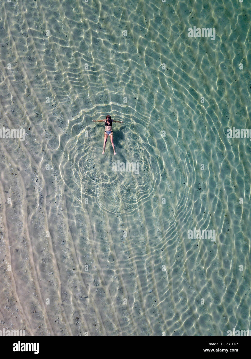 Indonesia, Bali, vista aerea del Karma Kandara beach, una donna galleggianti in acqua Foto Stock