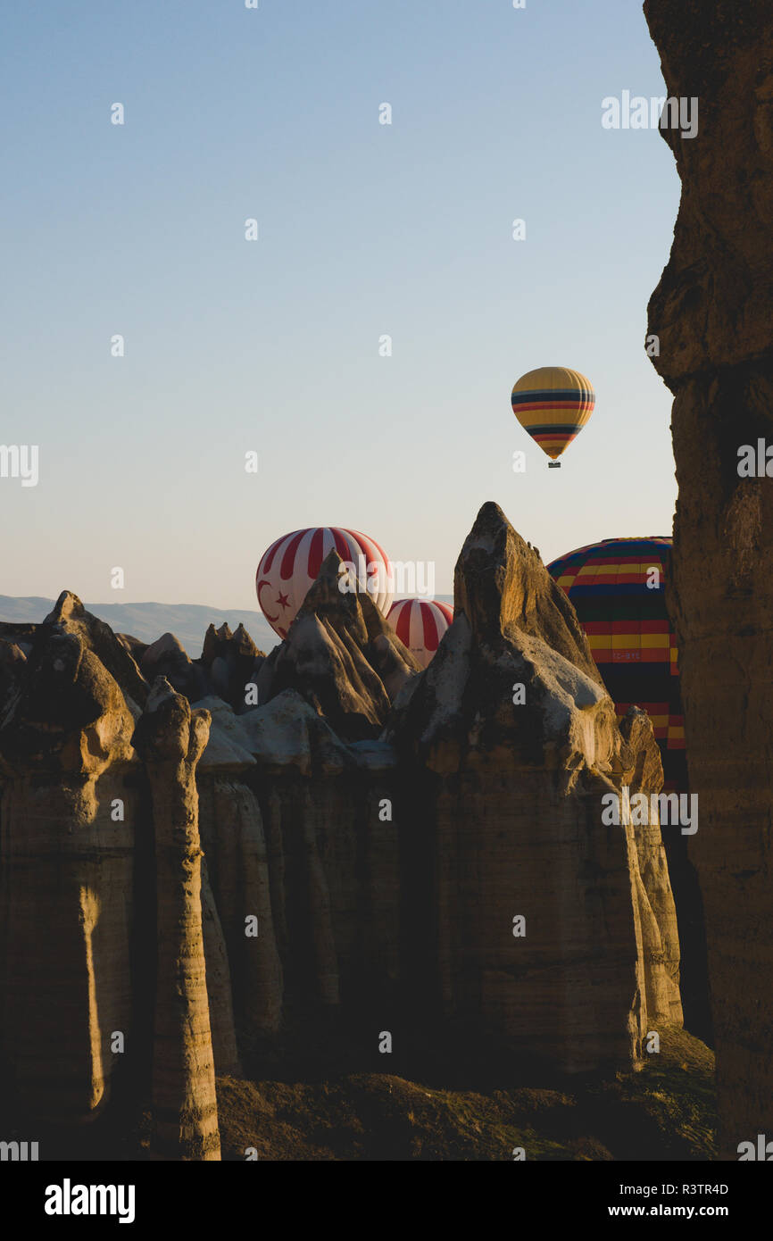 Goreme, Turchia - Aprile 4, 2012: i palloni ad aria calda per i turisti volare sopra le formazioni rocciose a sunrise nella valle della Cappadocia. Foto Stock