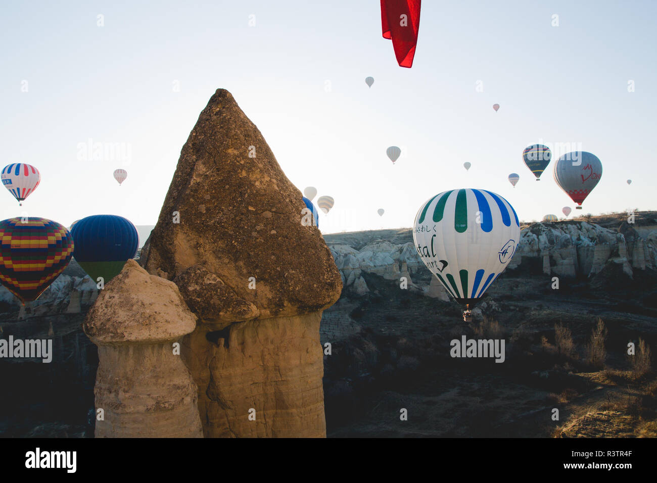 Goreme, Turchia - Aprile 4, 2012: i palloni ad aria calda per i turisti volare sopra le formazioni rocciose a sunrise nella valle della Cappadocia. Foto Stock