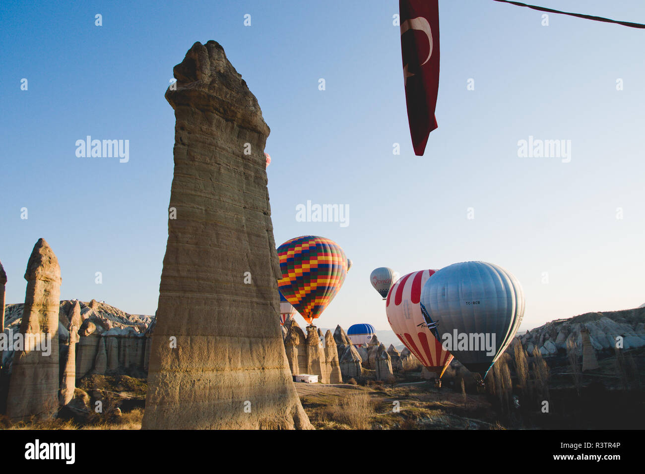 Goreme, Turchia - Aprile 4, 2012: i palloni ad aria calda per i turisti volare sopra le formazioni rocciose a sunrise nella valle della Cappadocia. Foto Stock