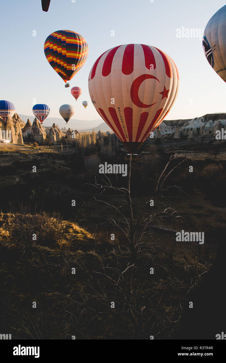 Goreme, Turchia - Aprile 4, 2012: i palloni ad aria calda per i turisti volare sopra le formazioni rocciose a sunrise nella valle della Cappadocia. Foto Stock