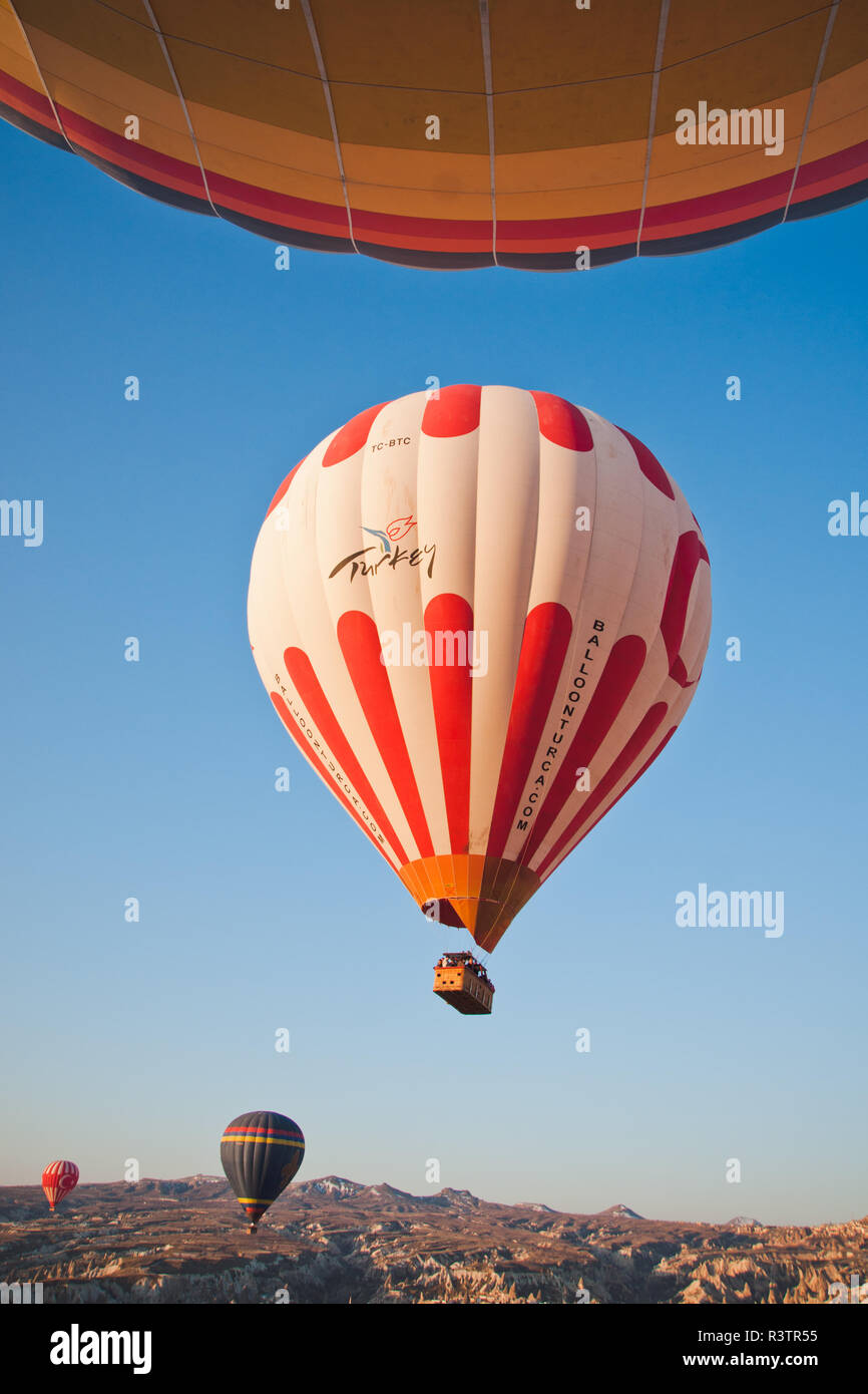 Goreme, Turchia - Aprile 4, 2012: i palloni ad aria calda per i turisti volare sopra le formazioni rocciose a sunrise nella valle della Cappadocia. Foto Stock