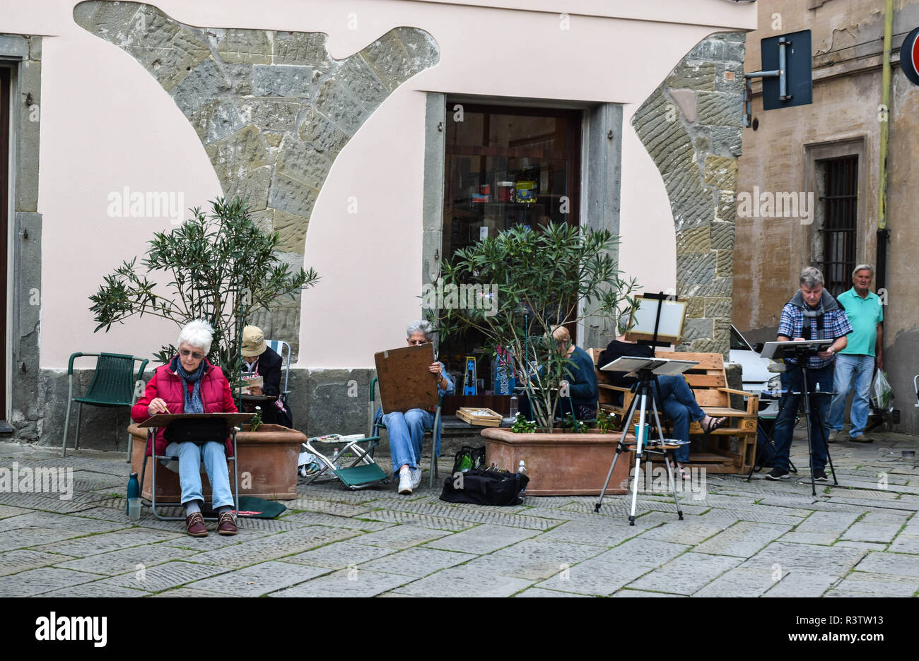 I partecipanti di una pittura inglese corso nella centrale piazza nei giorni di mercato a Fivizzano, Toscana, Italia.. Foto Stock