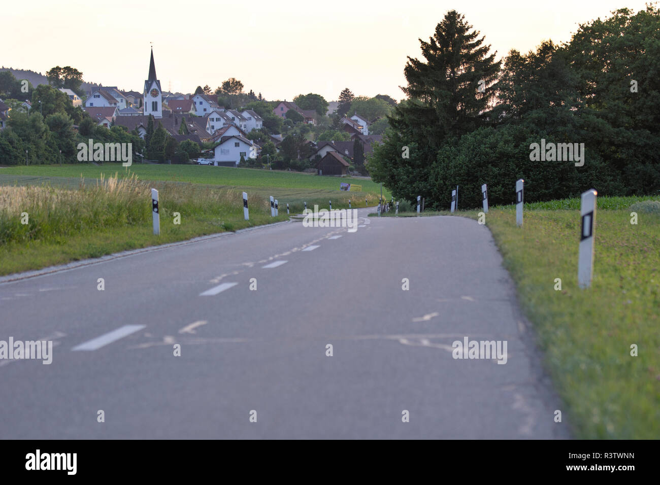 Piccola strada tortuosa che conduce al piccolo villaggio svizzero Foto Stock