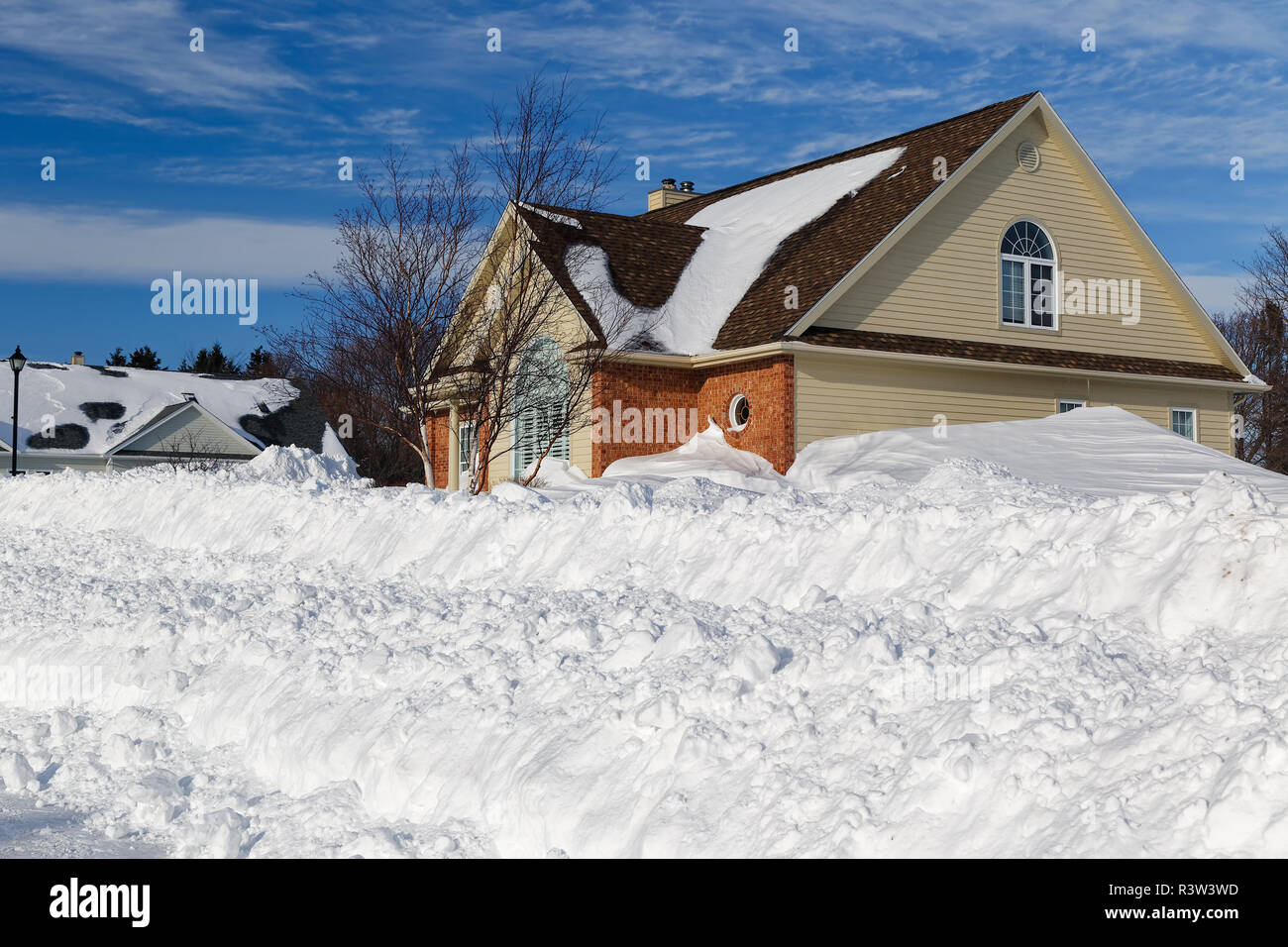 Grandi snowbanks lungo una strada arato in Nord America subdivison. Foto Stock