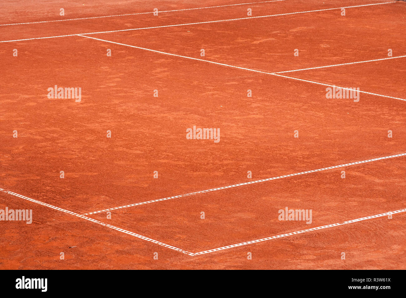 Parte di vuoto utilizzato campo da tennis in argilla rossa parco giochi superficie con linee bianche closeup Foto Stock