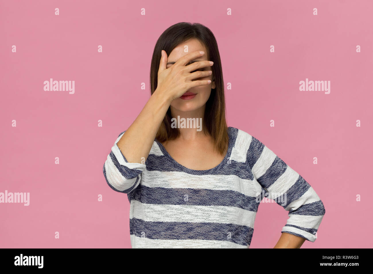 Giovane donna in depressione coprire gli occhi con la mano. Il gesto di arresto Foto Stock