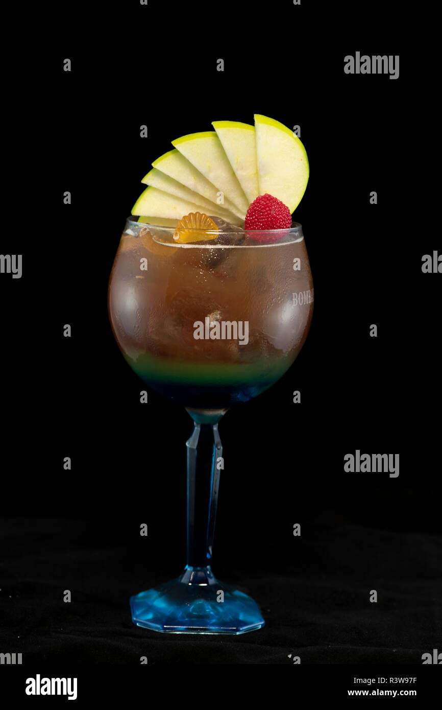 Speciale tè ghiacciato cocktail con coke, rum leggero, curacao blu e dolce e aspro isolato con sfondo nero Foto Stock
